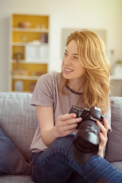 Sonriendo mujer feliz sosteniendo una cámara réflex digital — Foto de Stock