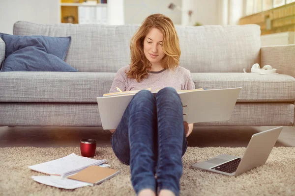 Pretty young girl doing her studies at home — Stok fotoğraf