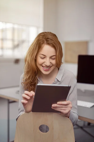 Mujer joven sonriente usando una tableta — Foto de Stock