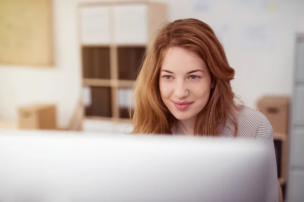 Mulher muito jovem trabalhando em um computador desktop — Fotografia de Stock