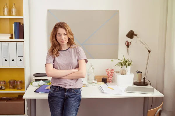 Empresária sentada na borda de sua mesa — Fotografia de Stock