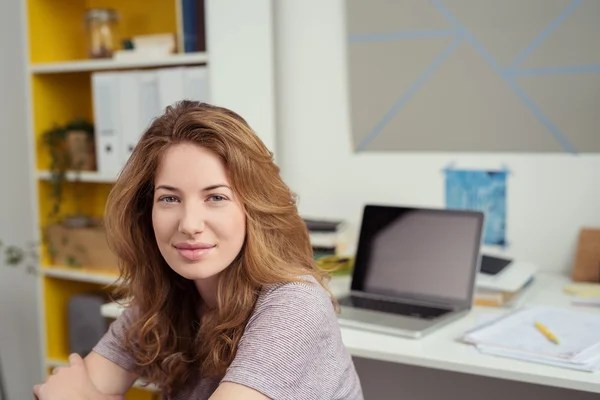 Mujer joven en su sala de estudio sonriendo ante la cámara — Foto de Stock