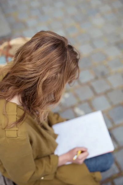 Chica rubia escribiendo en el cuaderno en la vista superior — Foto de Stock