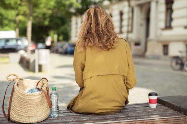 Rear View of a Blond Girl Sitting on the Bench Stock Photo