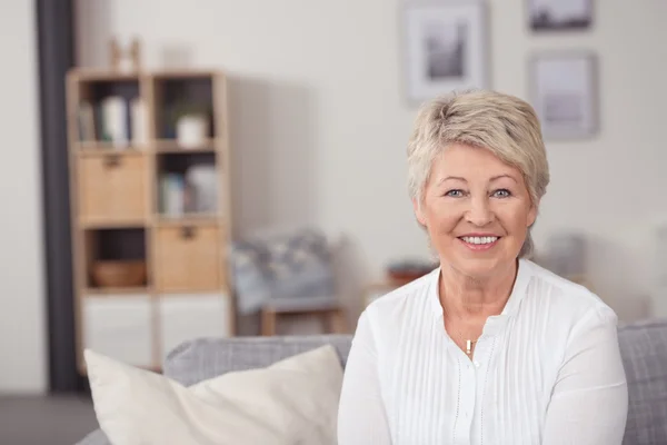 Smiling Middle Aged Woman Sitting at the Sofa — Stok fotoğraf