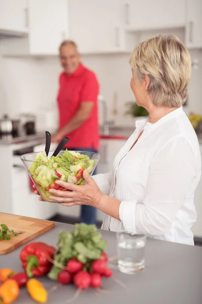 Mann und Frau bereiten in der Küche frischen Salat zu — Stockfoto