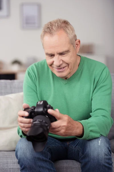 Mann mittleren Alters schaut sich Bilder im Internet an — Stockfoto