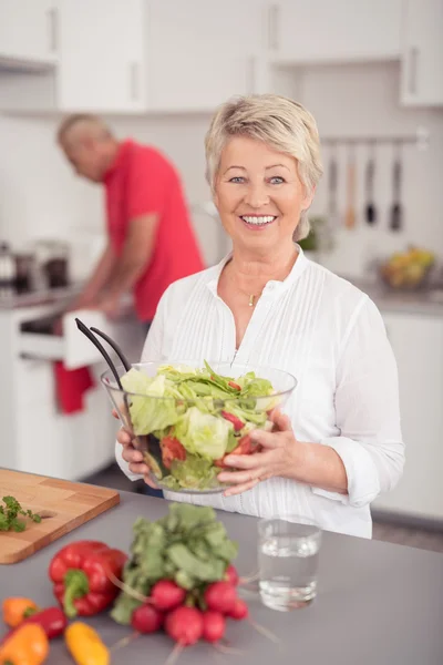 Feliz esposa sosteniendo un tazón de ensalada de verduras frescas — Foto de Stock