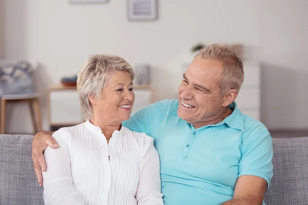 Feliz casal de meia-idade conversando no sofá — Fotografia de Stock