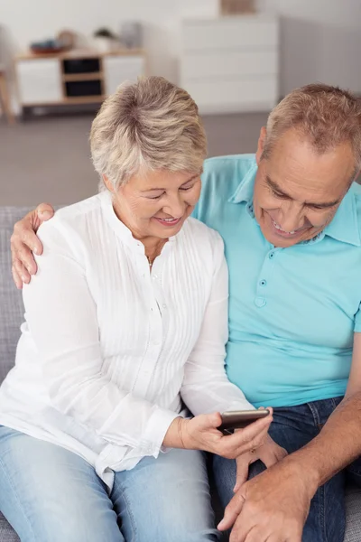 Happy Senior Couple Looking at Phone Together — Stok fotoğraf