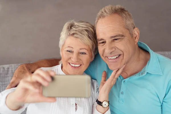 Супружеская пара средних лет делает телефонное селфи — стоковое фото
