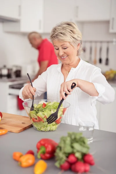 Esposa feliz preparando ensalada fresca en la cocina —  Fotos de Stock