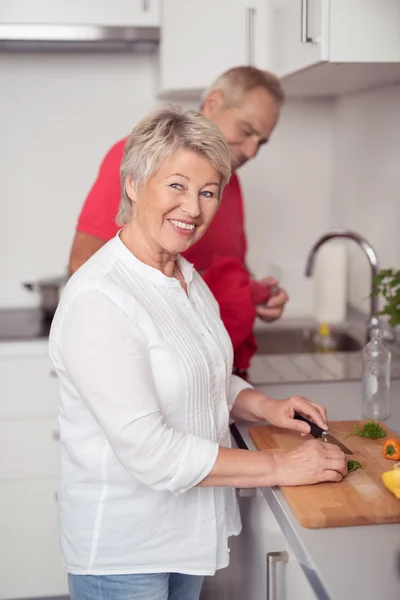 Feliz esposa rebanando ingredientes de alimentos en la cocina — Foto de Stock