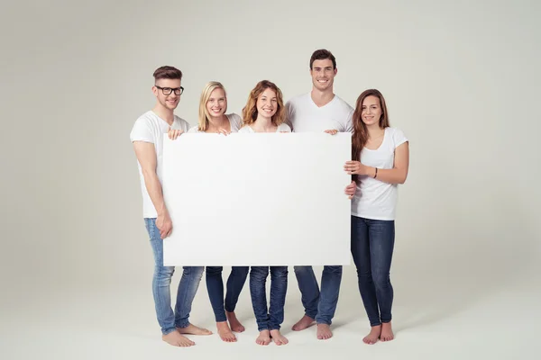 Amigos alegres mostrando tablero blanco vacío — Foto de Stock