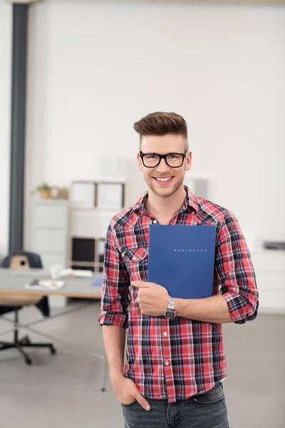 Hombre alegre sosteniendo una carpeta dentro de la oficina — Foto de Stock