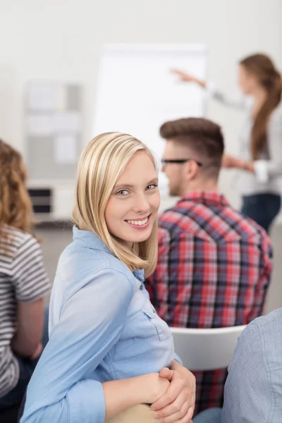 Hübsche Frau lächelt während eines Treffens in die Kamera — Stockfoto