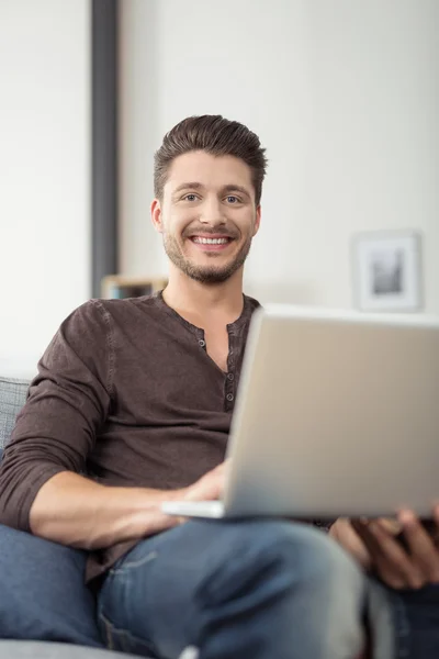 Cheerful Guy with Laptop Sitting on the Couch — Φωτογραφία Αρχείου