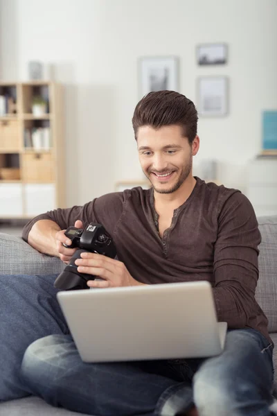 Young Man with Laptop and Camera at the Couch — Stock Fotó