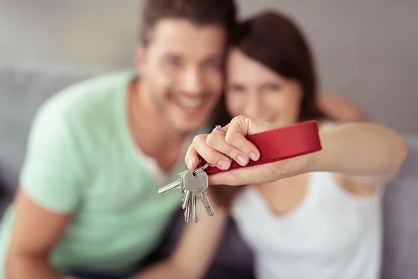 Giovane coppia mostrando le loro chiavi di casa presso la fotocamera — Foto Stock