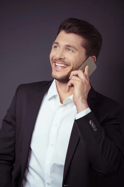 Feliz hombre de negocios hablando por teléfono contra Gray — Foto de Stock