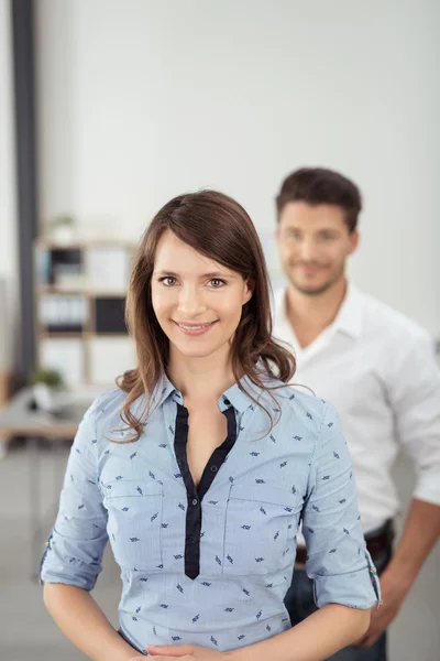 Office Woman Smiles at Camera In Front her Partner — Zdjęcie stockowe