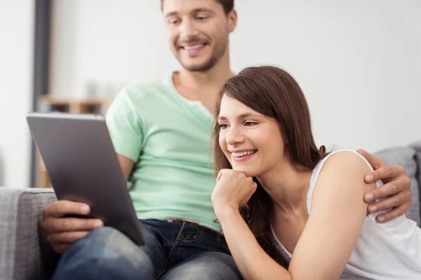 Dulce pareja feliz viendo algo en la tableta —  Fotos de Stock
