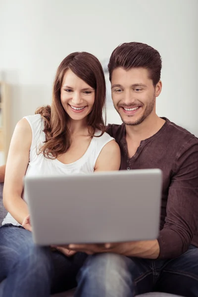 Heureux jeune couple regarder drôle vidéo sur ordinateur portable — Photo