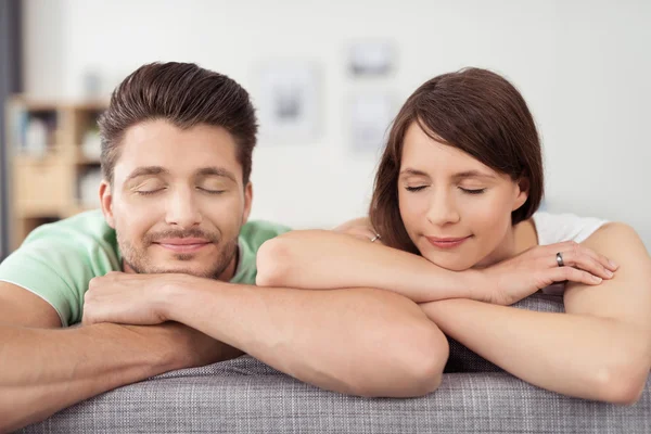 Couple on Couch Leaning on Arms with Eyes Closed — Stock Photo, Image