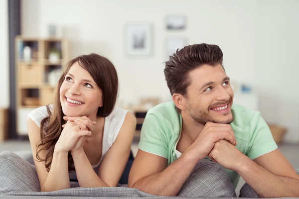 Feliz pareja joven reflexiva mirando hacia arriba juntos — Foto de Stock