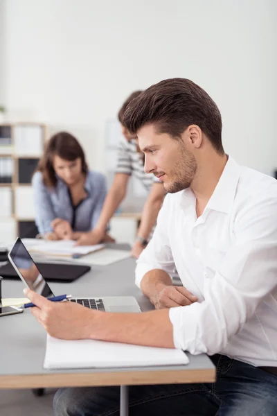 Uomo d'affari guardando dritto al suo schermo del computer portatile — Foto Stock