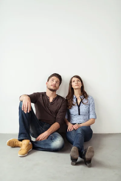 Young Couple Resting on Floor with Pensive Faces — Stock Photo, Image