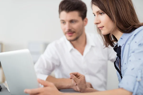 Büro-Paar schaut gemeinsam auf Laptop-Bildschirm — Stockfoto