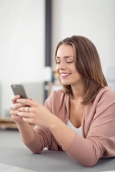 Glückliche Frau, die jemandem per Handy SMS schickt — Stockfoto