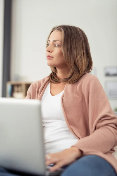 Eftertänksam kvinna med Laptop undersöker avstånd — Stockfoto