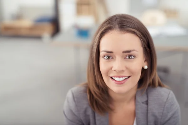 Lächelnde hübsche Büroangestellte, die in die Kamera schaut — Stockfoto