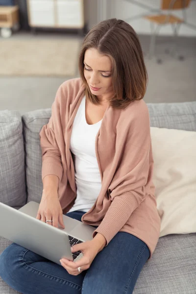 Wanita muda menggunakan Laptop Computer di Sofa — Stok Foto