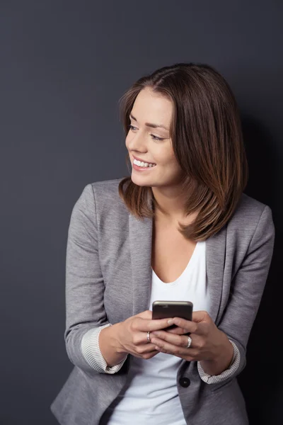 Heureuse femme d'affaires avec téléphone regardant vers la gauche — Photo