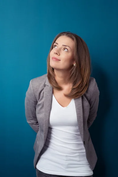 Mujer de oficina pensativa de pie contra la pared azul — Foto de Stock