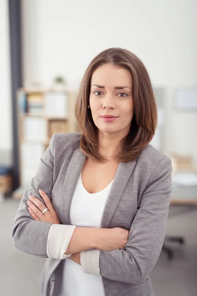Selbstbewusste hübsche Bürofrau blickt in die Kamera — Stockfoto