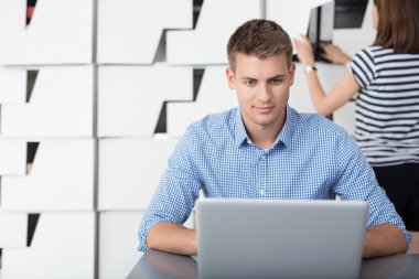 Young Businessman Using his Laptop on his Desk clipart