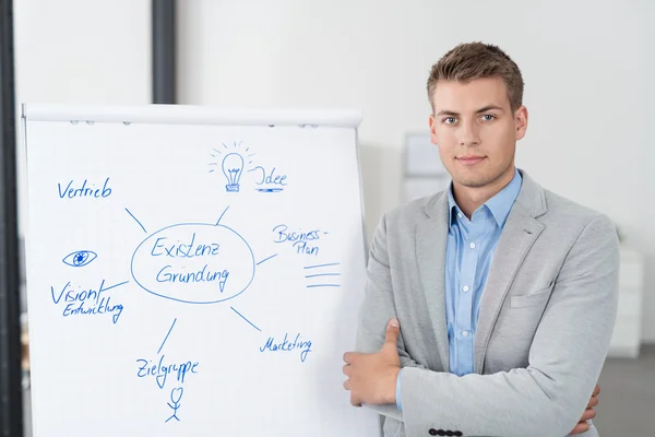 Jovem Empresário Apresentando um Diagrama em Cartaz — Fotografia de Stock