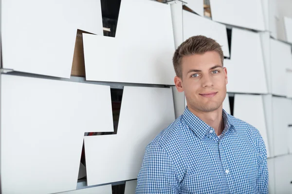 Sorrindo cara bonito ao lado armários de escritório — Fotografia de Stock