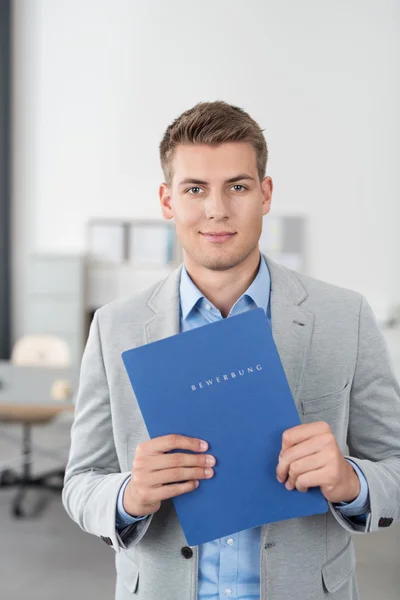 Smiling Young Businessman Holding a Blue Folder — Stock Photo, Image