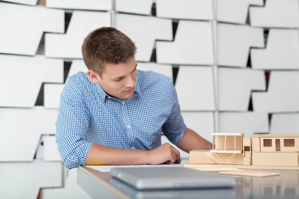 Designerin betrachtet Hausminiatur auf dem Tisch — Stockfoto