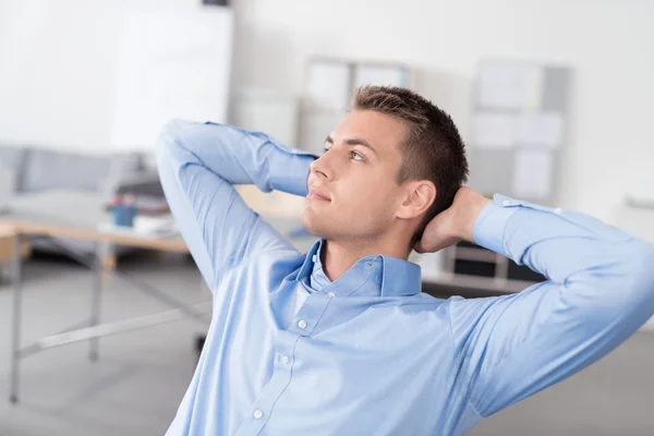 Nachdenklicher Büromensch lehnt sich auf seinem Stuhl zurück — Stockfoto