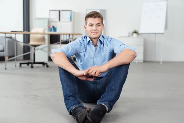 Office kille sitter på golvet, titta på kameran — Stockfoto