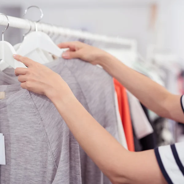 Kvinde shopping nyt tøj inde tøjbutik - Stock-foto