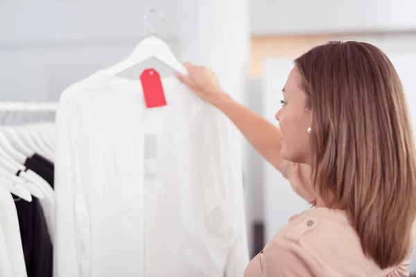 Frau betrachtet weißes Hemd in einem Geschäft — Stockfoto