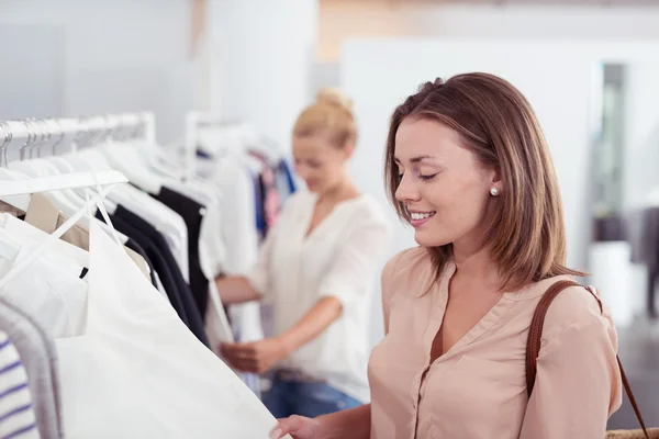 Femme attrayante regardant les vêtements dans un magasin — Photo