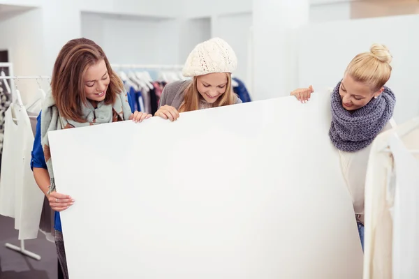 Mädchen in einem Geschäft betrachten das leere Plakat — Stockfoto